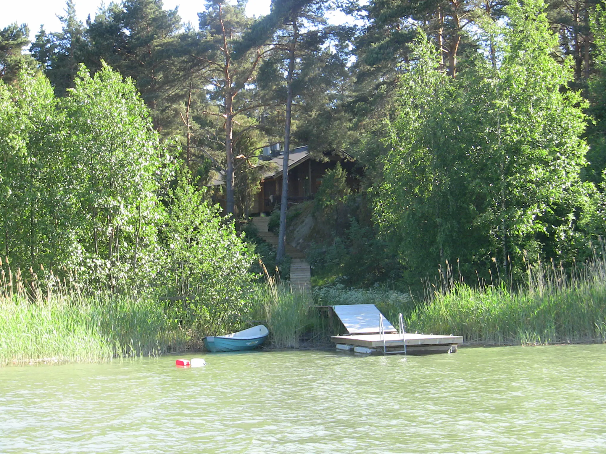 Mökki 2 ja laituri merestä päin, vene laiturissa