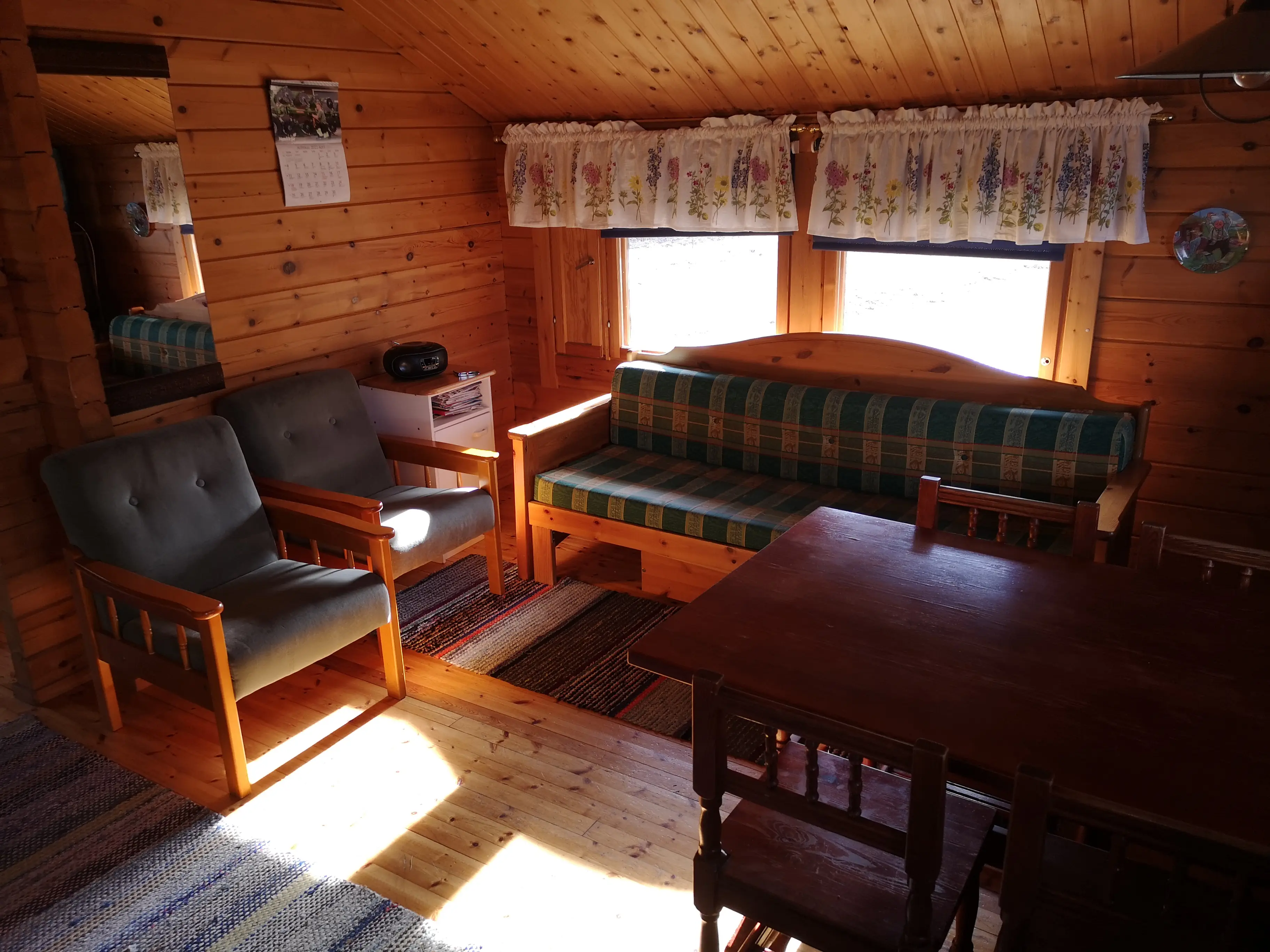 Sohva, ikkunaverhot ja iltapäivän valo